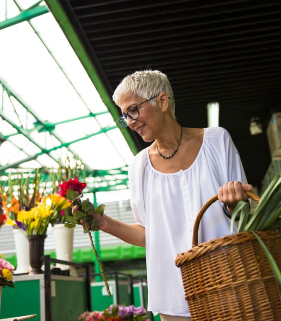 a woman with a basket of flowers in a greenhouse