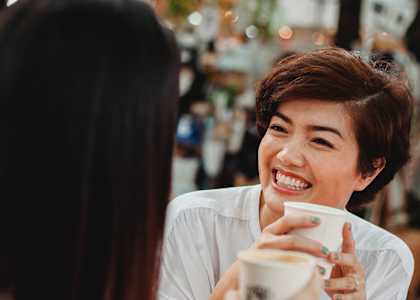 Two women having a conversation over a cup of coffee.