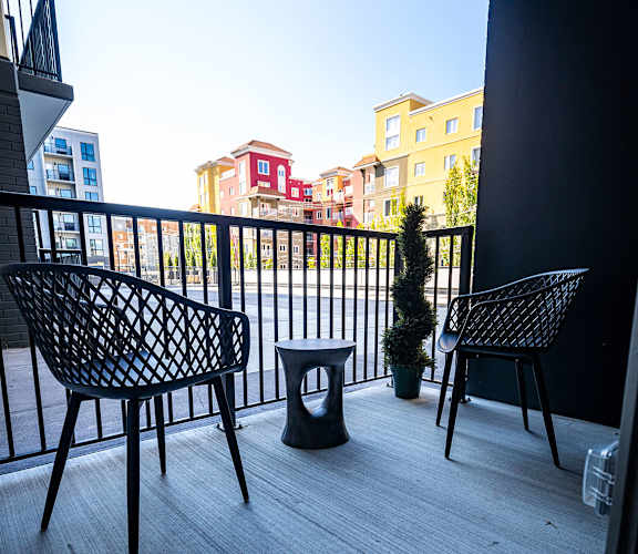 a balcony with chairs and a table on a balcony