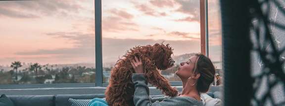 a woman sitting on a couch with her dog