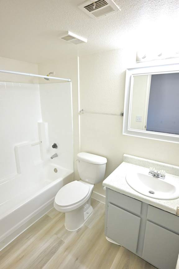 A white toilet and sink in a small bathroom.