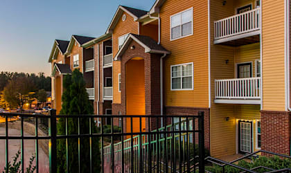 an apartment complex with a pool at dusk