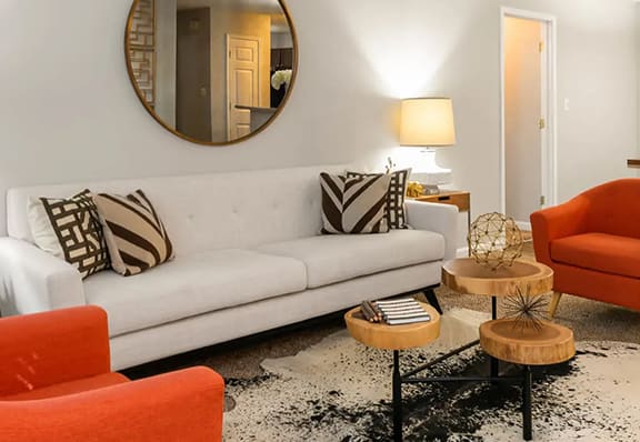 a living room with a white couch and two orange chairs