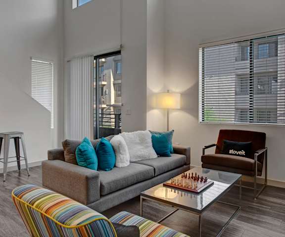 The living room with a couch, coffee table, decorations, a TV, and balcony at Escape. 