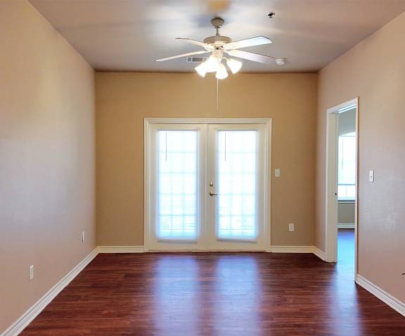 A room with a ceiling fan and a door with a window.