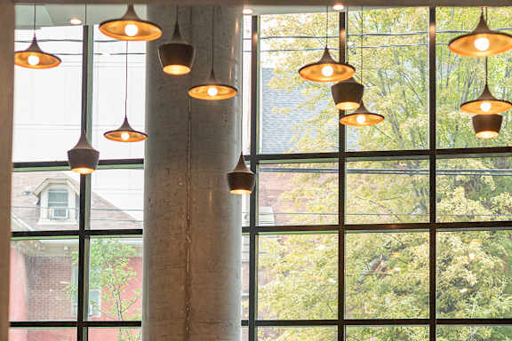 a lobby with chairs and a column and large windows