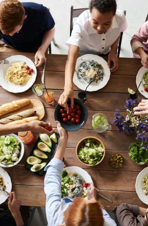 a group of people sitting around a table eating food