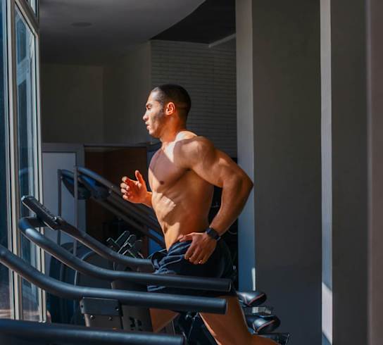 a man running on a treadmill in a gym