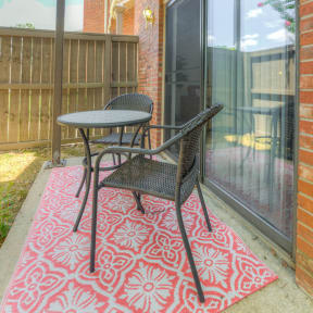 a patio with a table and chairs on a porch at Brightwaters Apartments, Little Rock, Arkansas