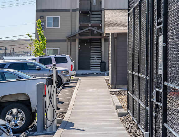 A parking lot with cars and a building in the background at Westgate Apartment Homes, Pendleton, OR, 97801