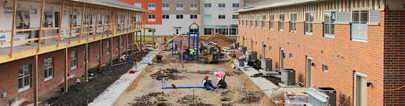 people working in a construction site next to a building