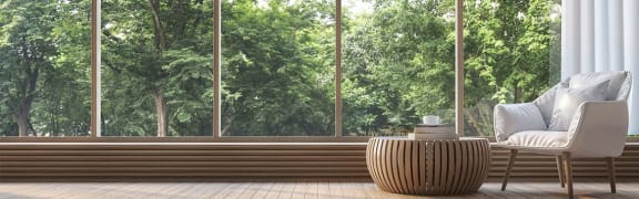 White chair in front of a treescape seen through window
