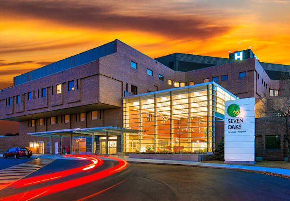 A building with a large glass window and a sign that says "OAS" in front of it.