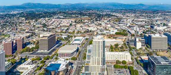 A cityscape with a large building in the foreground and smaller buildings in the background.