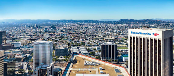 A cityscape with a Bank of America building in the foreground.