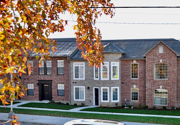 a large brick house with a gray roof and white trim