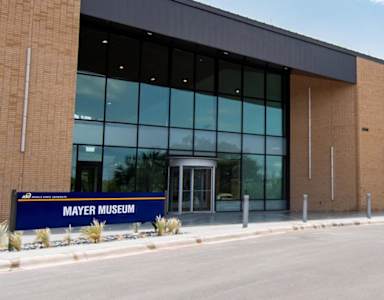 The Mayer Museum is a large building with a blue sign in front.