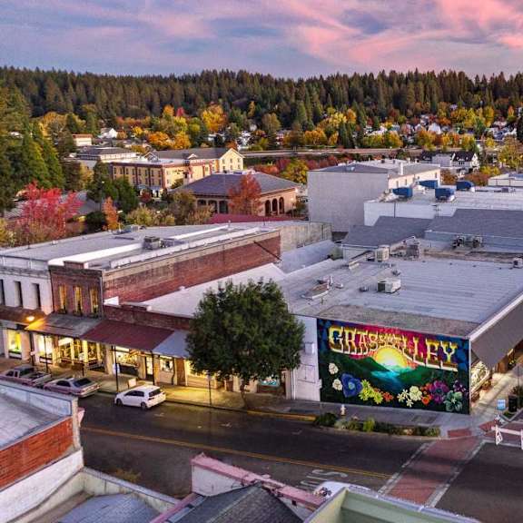 A street view of a town with a large building in the center that has a sign that says "CHRISTMAS".
