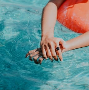a woman in a pool holding her hands in the water