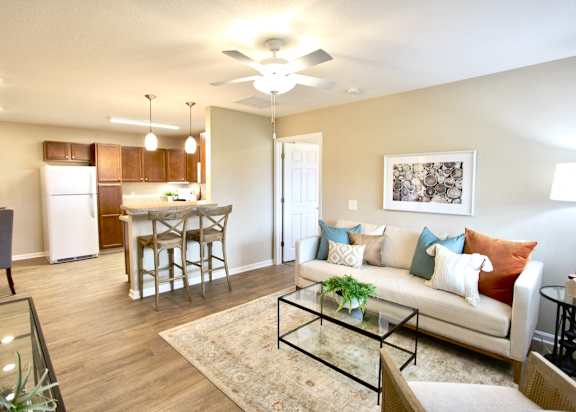A living room with a couch, chairs, and a dining table.