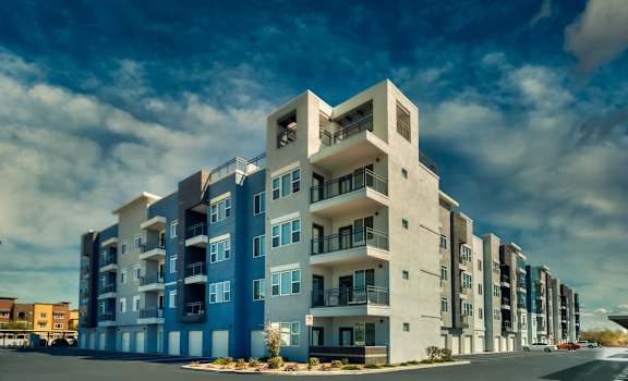Exterior view of Cuvee apartment building with a blue sky background