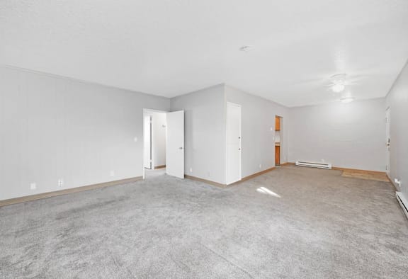 an empty living room with white walls and carpet