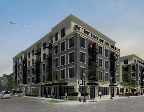 A modern apartment building with a parking lot in front.