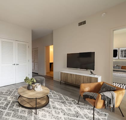 A modern living room with a grey sofa, a wooden coffee table, and a television.