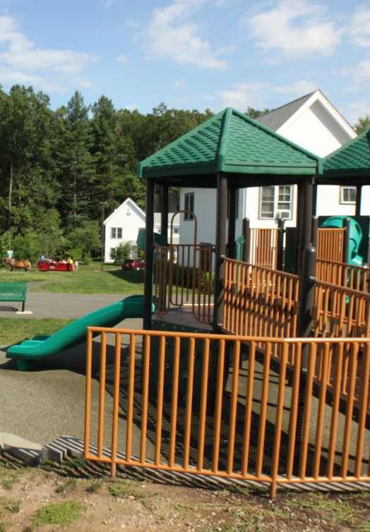 A playground with a red and yellow slide.