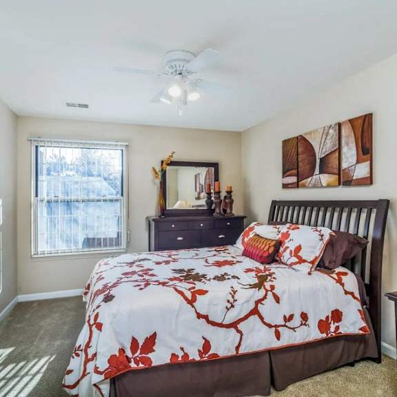 A bedroom with a bed, dresser, and mirror.