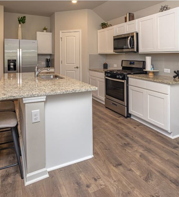 a kitchen with white cabinets and a granite counter top