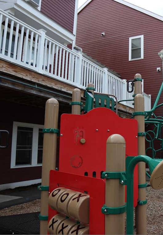 A playground with a red and yellow slide.