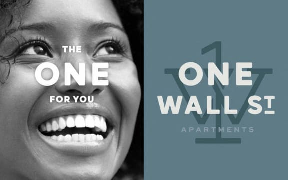 a black and white photo of a woman smiling and a one wall st advertising poster