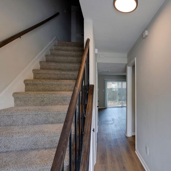 A staircase with a carpeted runner and wooden banister. at Savan Pointe, Savannah, 31406