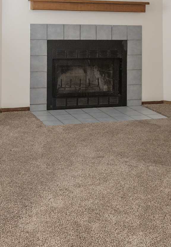 A fireplace with a wooden mantle above it.