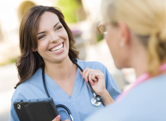 woman in blue scrubs wearing a stethoscope