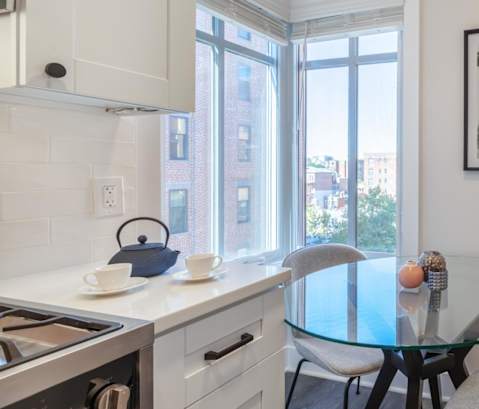 a kitchen and dining room with a large window and a table and chairs