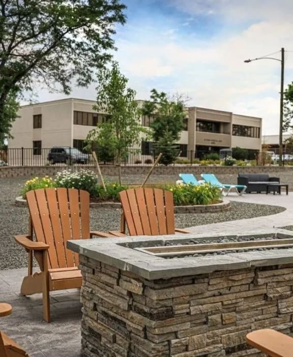 a patio with chairs and a fire pit
