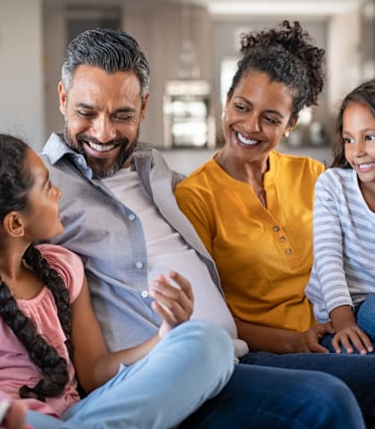 a family sitting on a couch with their daughter and granddaughter