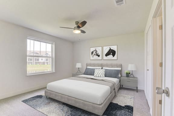 Master bedroom with large window and ceiling fan at Eagle Ridge Apartment Homes,  Michigan 49685