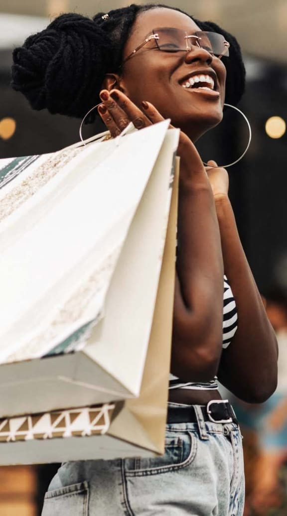 a woman holding shopping bags in a store