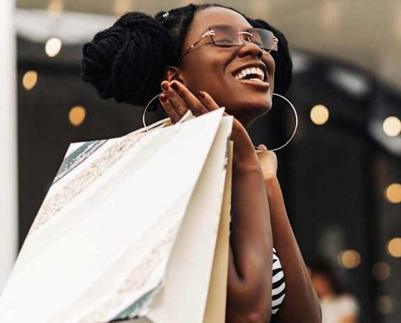 a woman holding shopping bags in a store