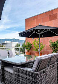 A patio with a table and chairs under umbrellas.at Catania, Pasadena, CA 91105