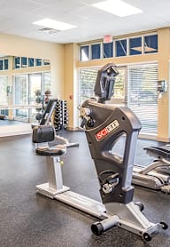 a gym with various exercise machines and windows at West Park Apartments