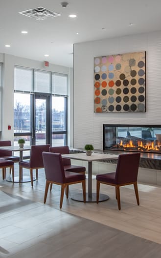 a Clubhouse lobby with a fireplace and a table with chairs with a stone kitchen island