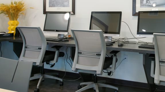 a group of computers on a desk in an office