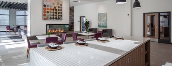 a large clubhouse kitchen and dining area with a fireplace and a table and chairs