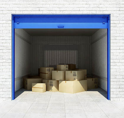 A storage unit with blue doors and cardboard boxes inside.