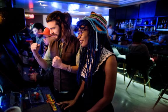 a man and a woman standing in front of a bar