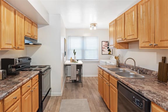 a kitchen with wooden cabinets and a black stove top oven at Rivers Landing Apartments, PRG Real Estate, Hampton, Virginia
